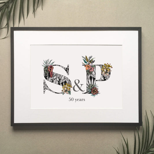 Personalised initial digital print of S & P. Initials are filled with fine liner drawings of imagery found in the rainforest. Butterflies, toucan, frog, tropical trees are included. Underneath initials ’50 years’ is printed.