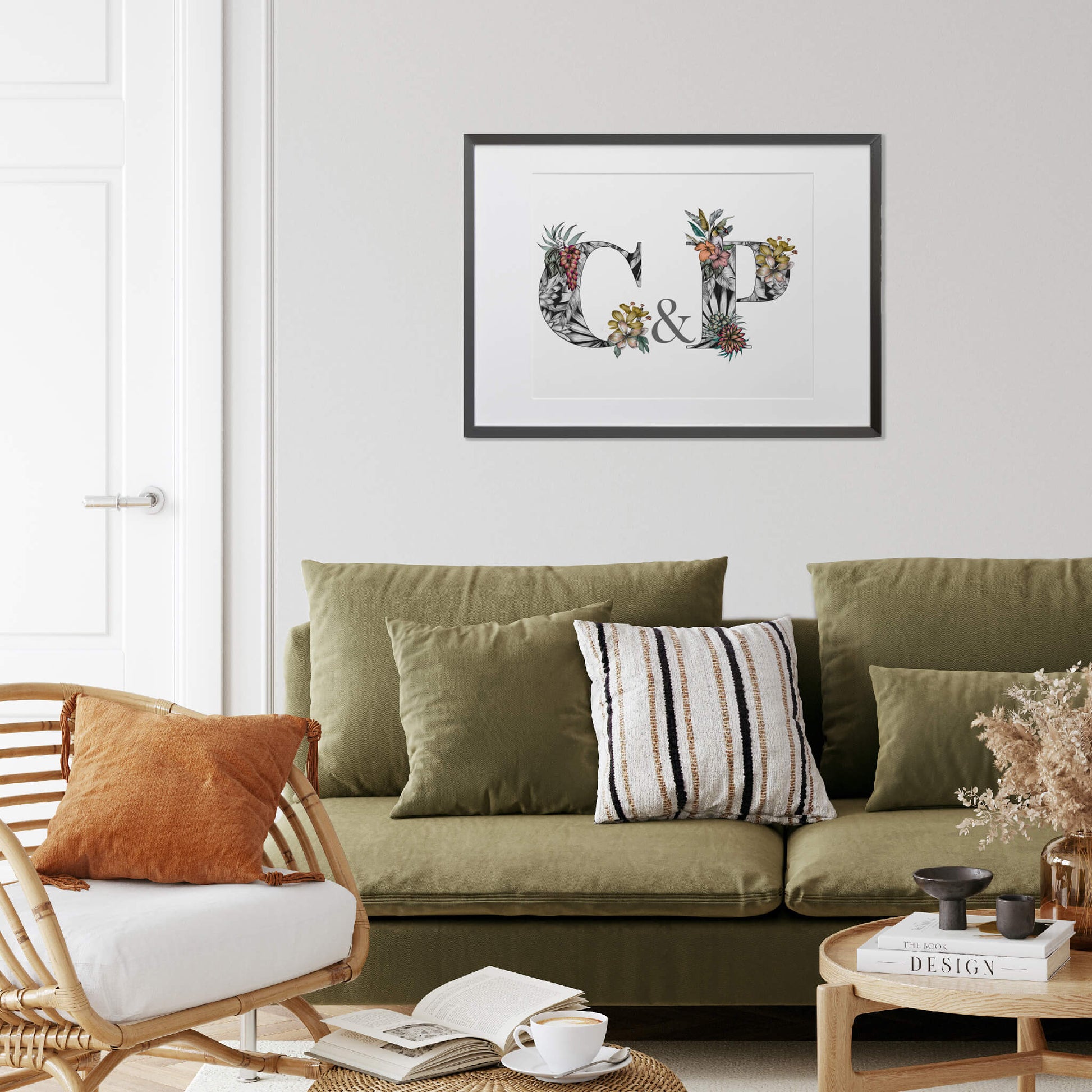 Personalised initial digital print of C & P. Initials are filled with fine liner drawings of imagery found in the rainforest. Butterflies, toucan, frog, tropical trees are included. Print is farmed and on the wall above a green sofa.