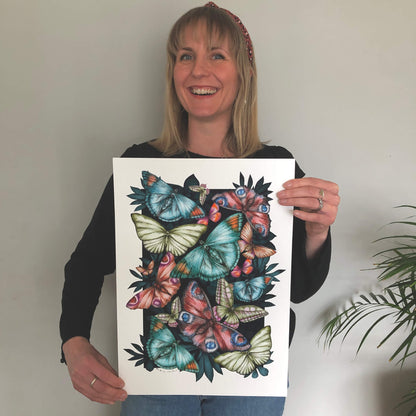 Smiling artist holding detailed hand-drawn butterfly art print .