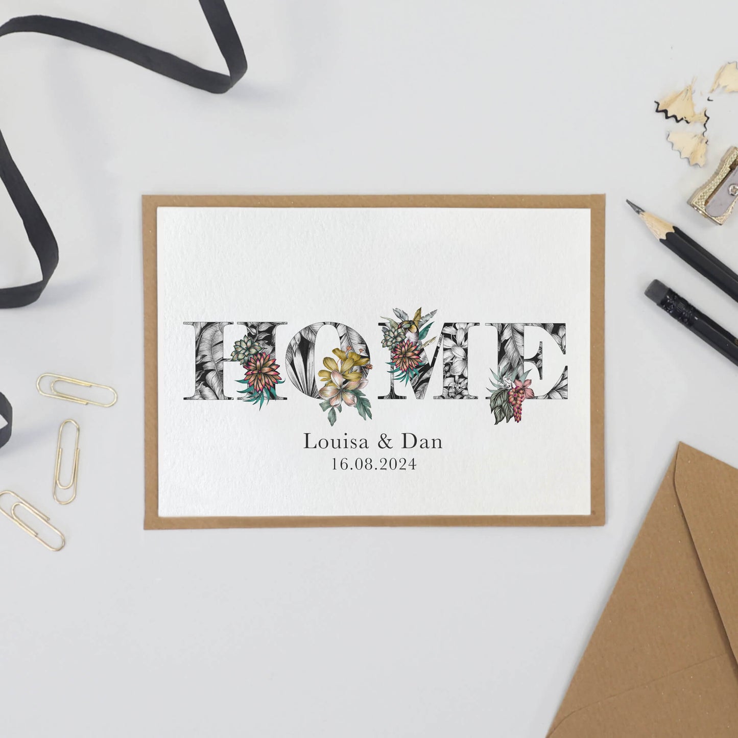 'HOME' printed on a card. Personalised with the couples names and moving in date printed underneath.