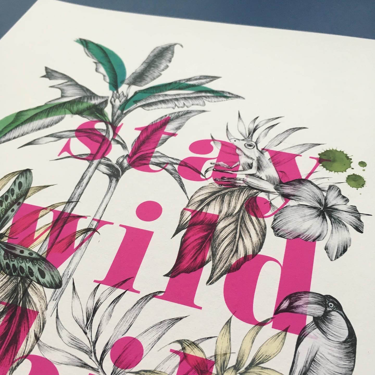 Close up details of art print created with fine liner and ink. A butterfly, frog and palm tree can be seen in detail. The text stay wild child can be seen in bright neon pink colour.