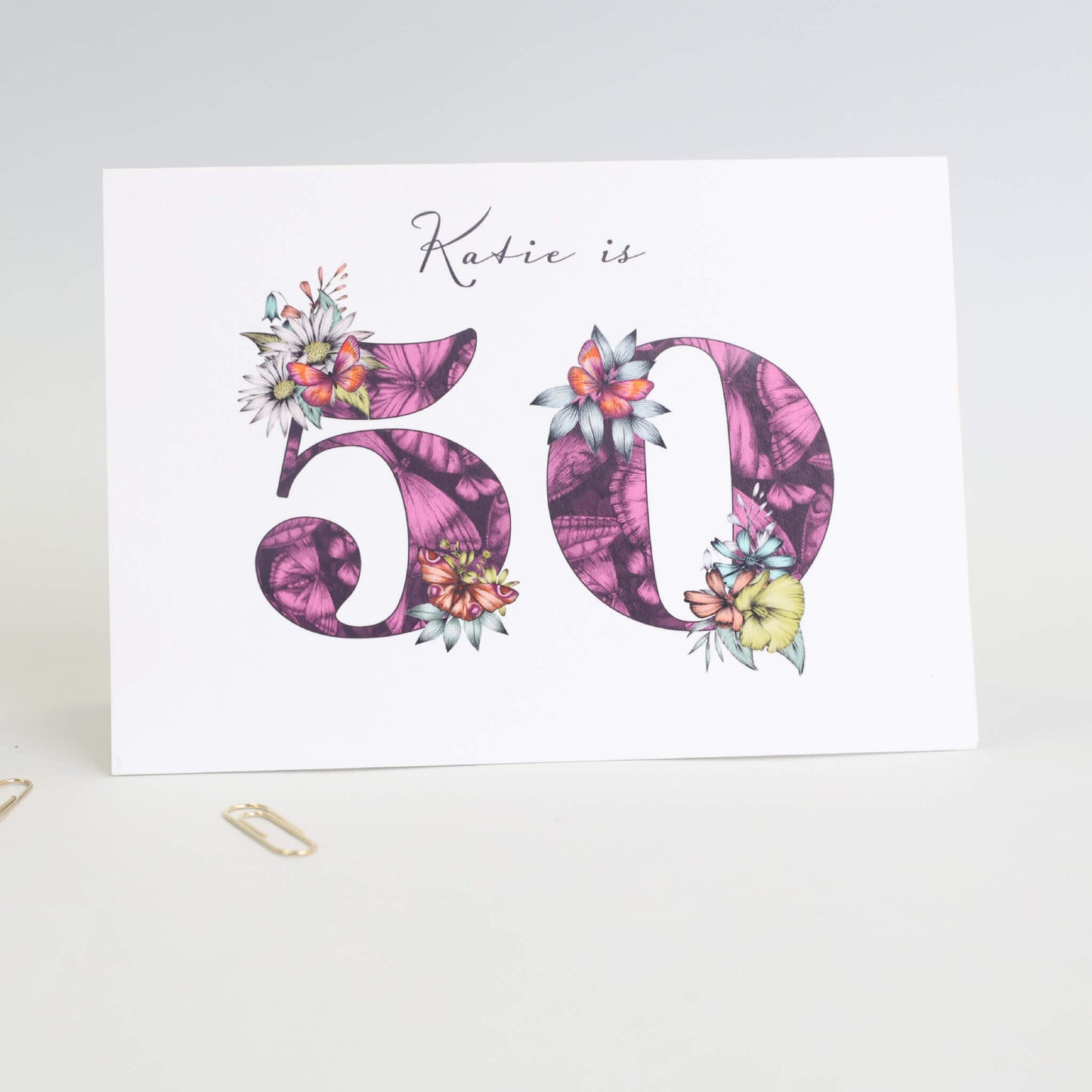 Personalised 50th birthday card with age filled with hand-drawn butterflies and flowers. 