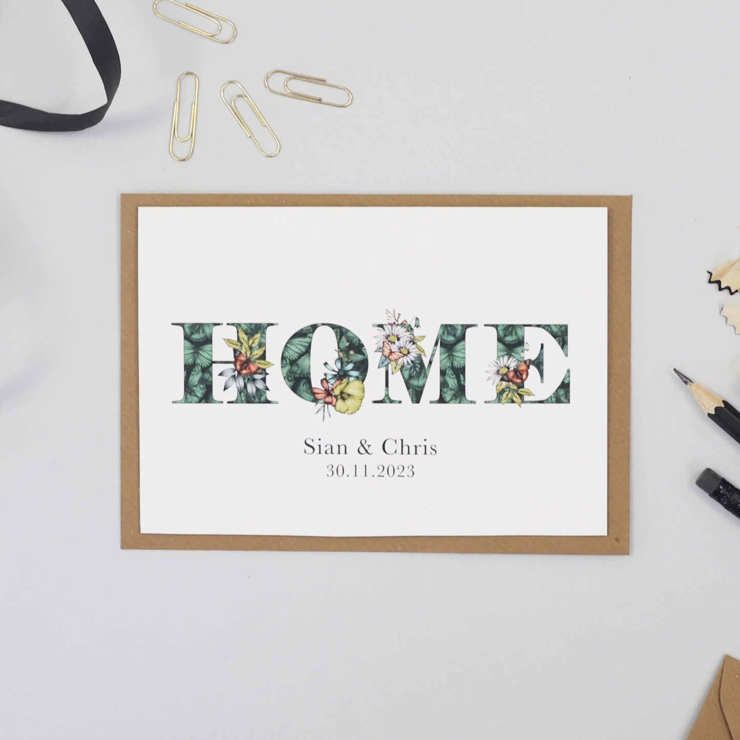 'HOME' printed on a card. Personalised with couples names and moving in date printed underneath.