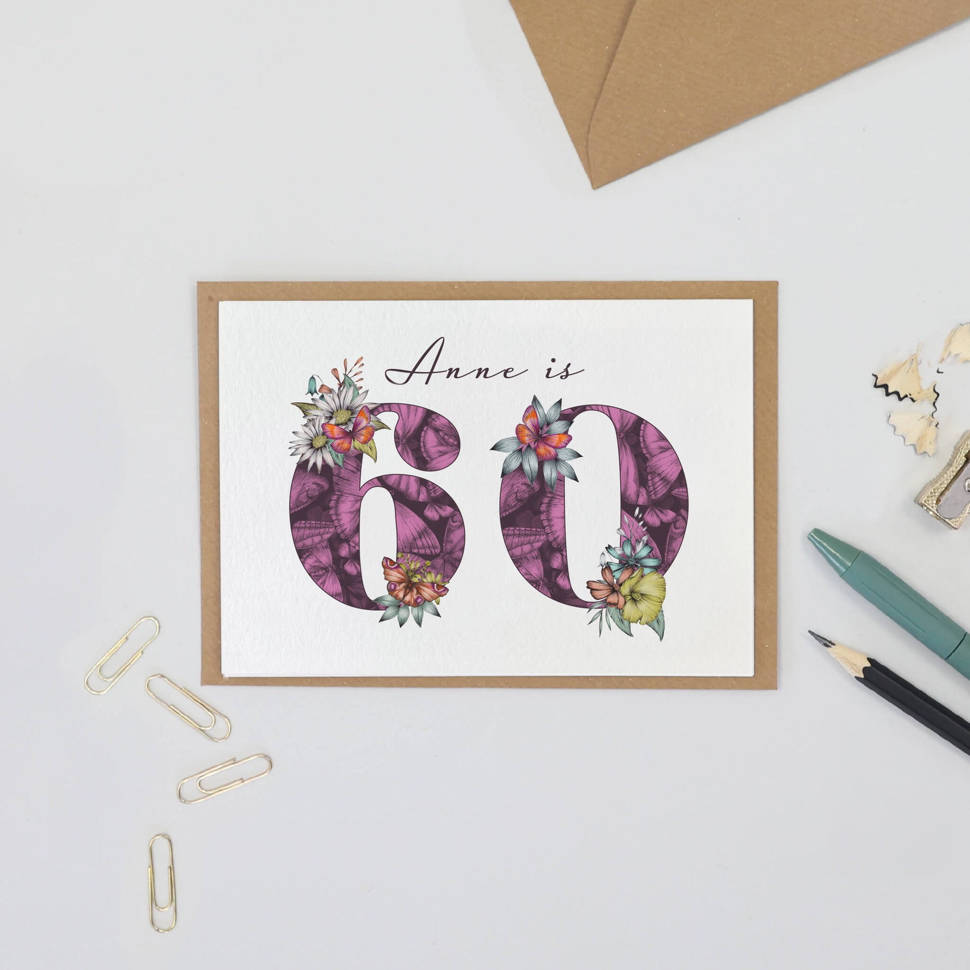 Personalised 60th birthday card with age filled with hand-drawn butterflies and flowers. Personalised with name above age.