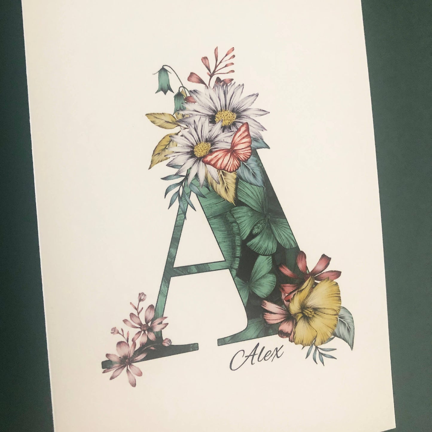 Green butterfly themed personalised ‘A’ initial birthday card with initial filled with hand-drawn butterflies and flowers. The recipients name and date of birth is incorporated into the design.