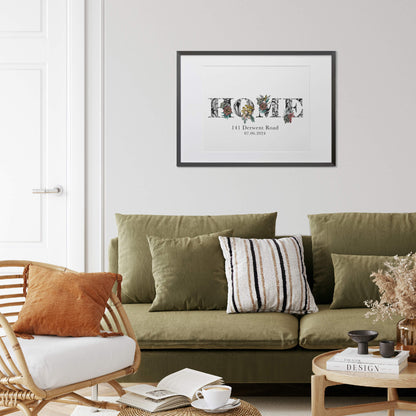 A print of the word 'HOME' filled with tropical imagery. Underneath the print is personalised with first ;ine of address and moving in date. Hung on wall in black frame above a green sofa