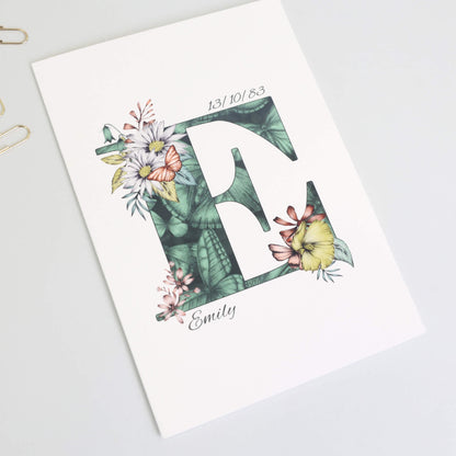 Green butterfly themed personalised ‘E’ initial birthday card with initial filled with hand-drawn butterflies and flowers. The recipients name and date of birth is incorporated into the design.