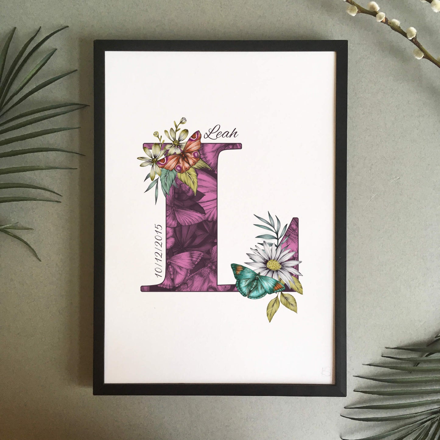 Personalised initial L print is filled with fine liner drawings of butterflies and flowers with a green theme and personalised with the recipients name and date of birth.