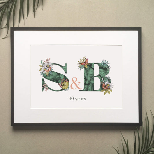 Personalised initial digital print of S & B. Initials are filled with fine liner drawings of butterflies and flowers. Underneath initials ’40 years’ is printed. B. Print is framed and surrounded with green leaves.