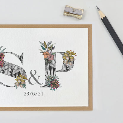 Personalised new home card with S & P initials filled with mainly black and white hand-drawn tropical flowers, leaves and animals. Wedding date is  printed underneath initials.